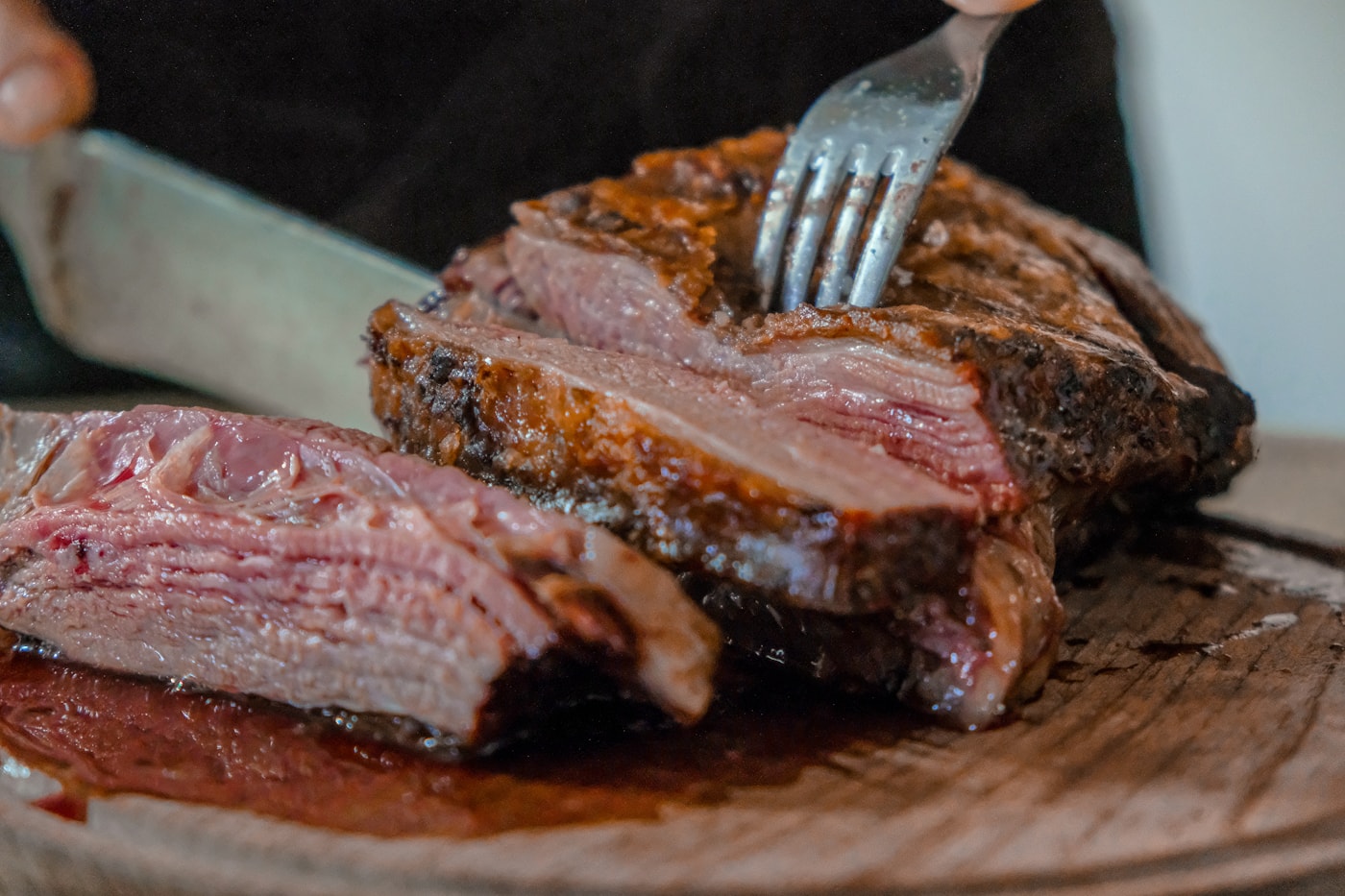 Carne marcada a la brasa con sal gruesa y fondo oscuro.