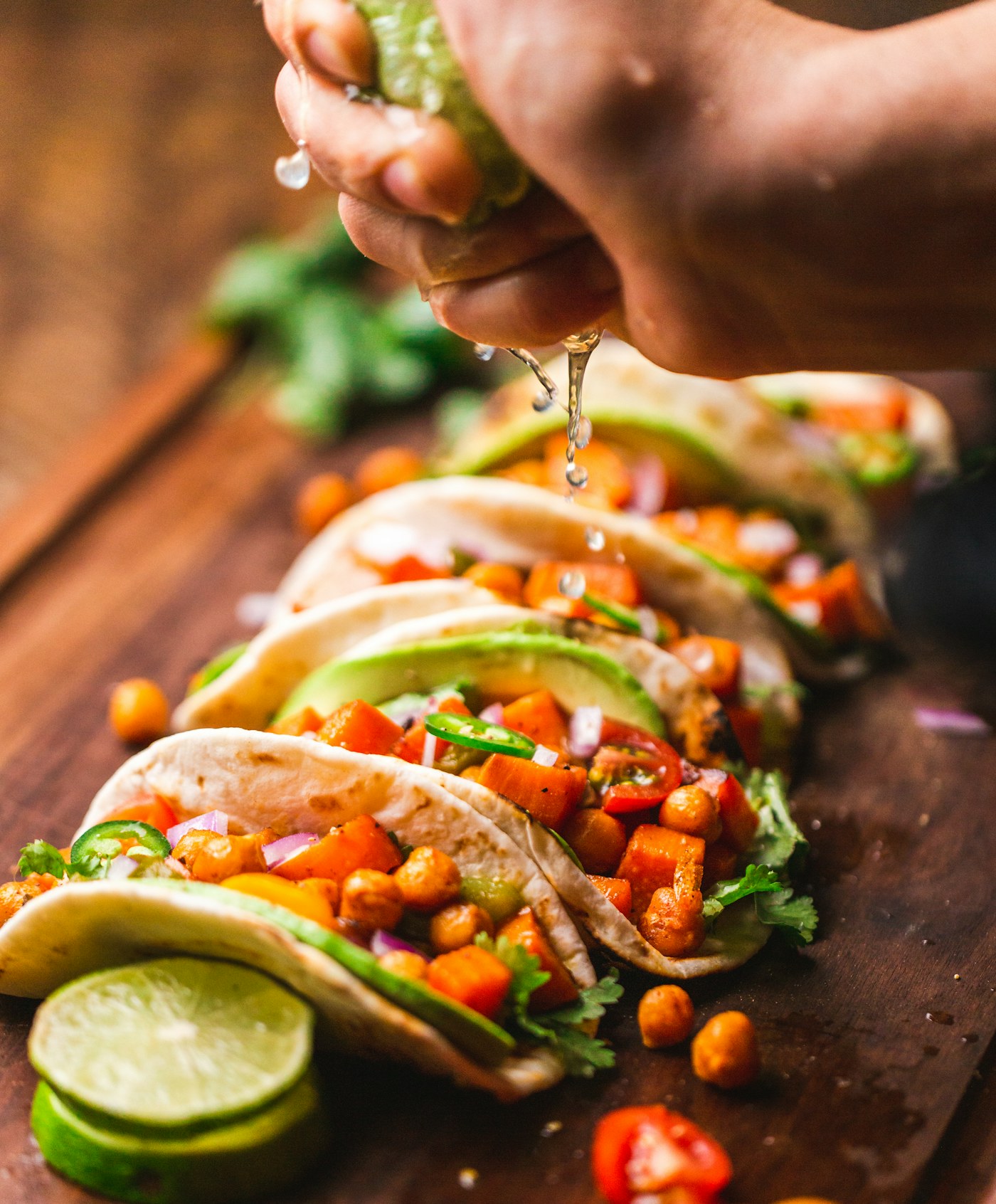 Tacos servidos con lima, cilantro y salsas de colores vivos.