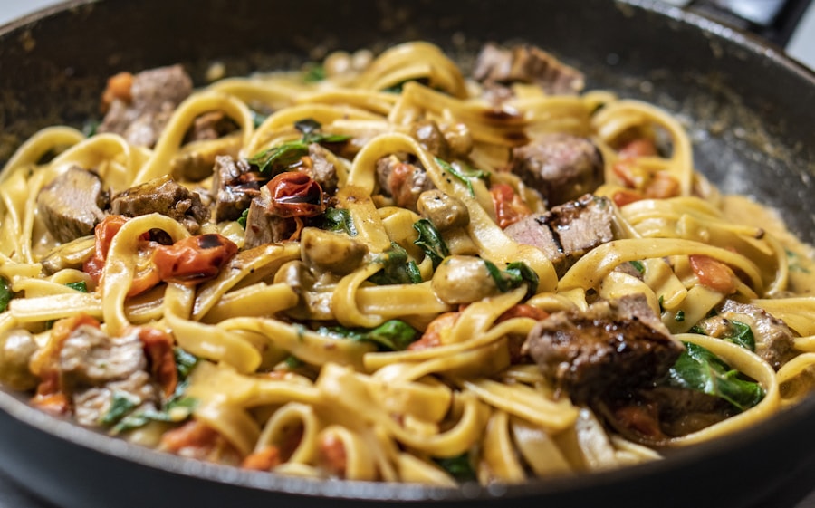Pasta servida en plato con salsa y hierbas frescas